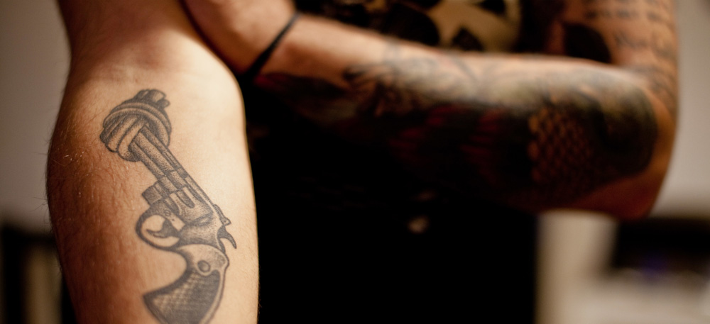Pistolen-Tattoo auf einem Unterarm