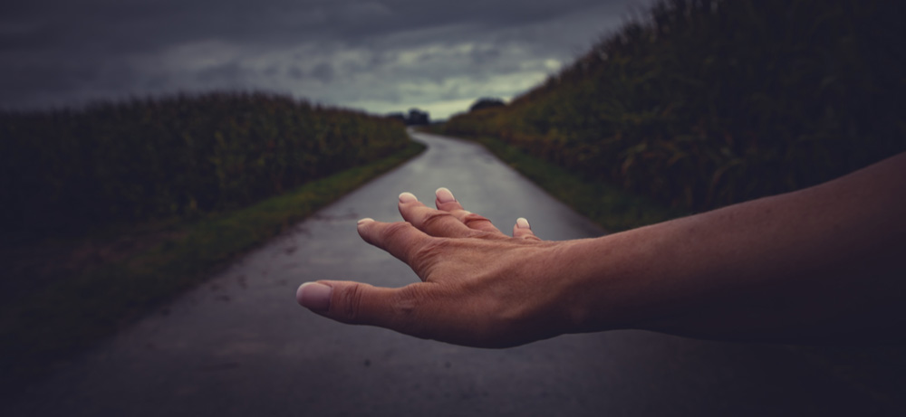Ein Hand schwebt über einer Straße Richtung Horizont